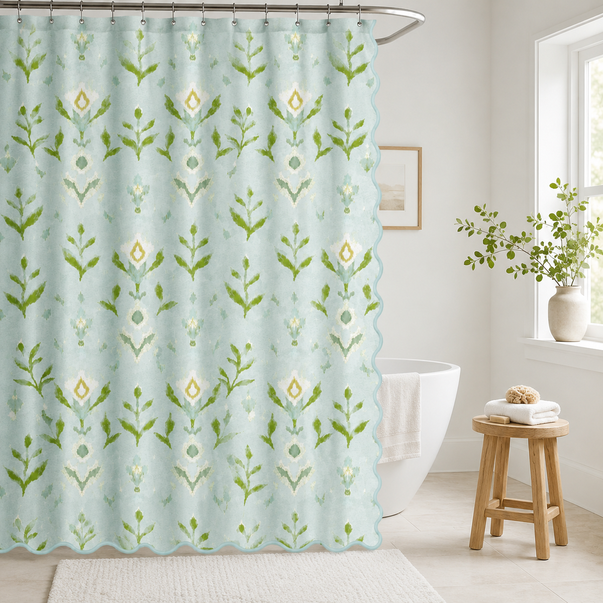 Laura Park's Petal Garden Aqua shower curtain with a scalloped blue trim, blue and green bathroom decor seen here with a bathtub, wood stool, and neutral bath mat. 