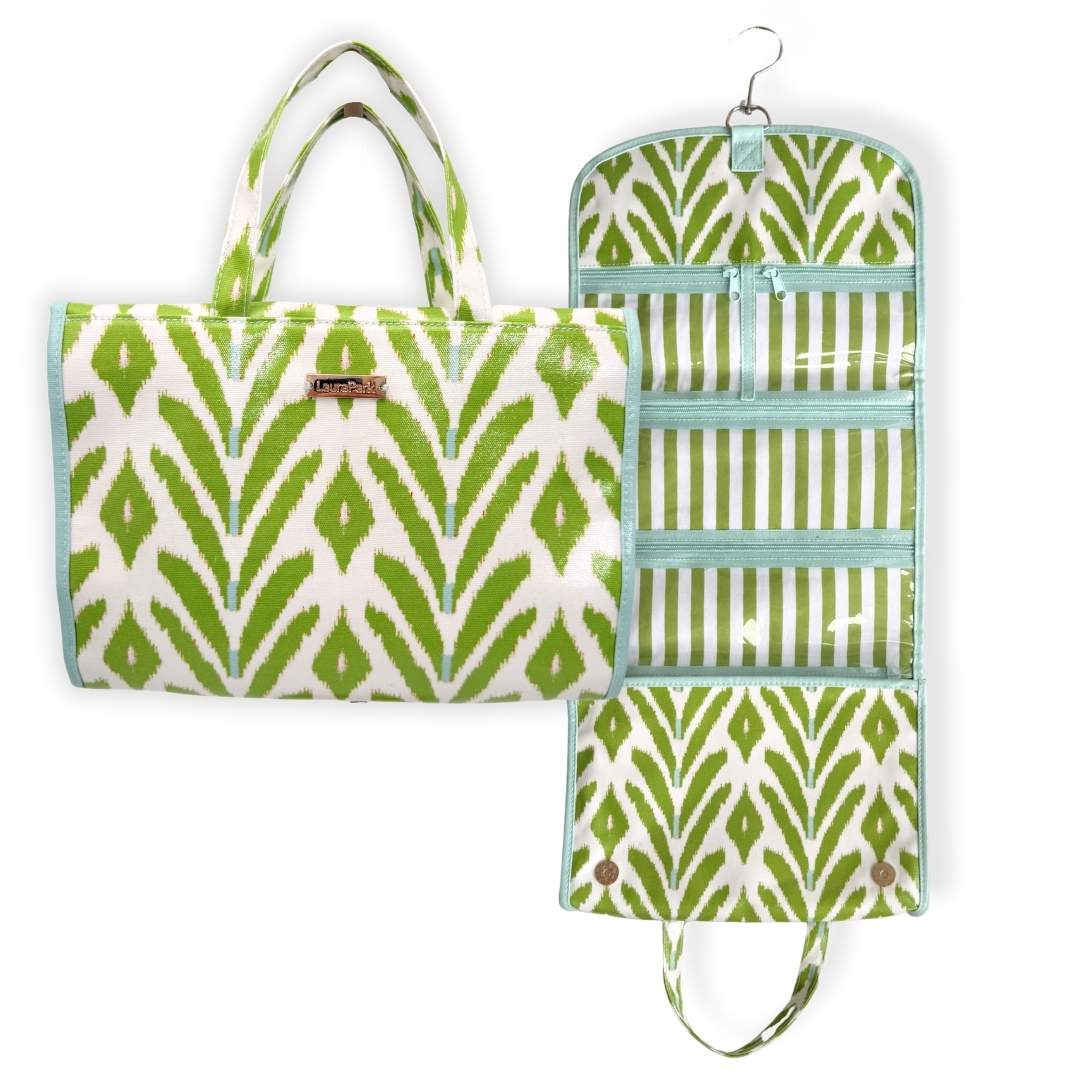 Green and white patterned travel hanging organizer bag with a wipeable inside lining and striped pockets with a blue outside lining and zipper. 