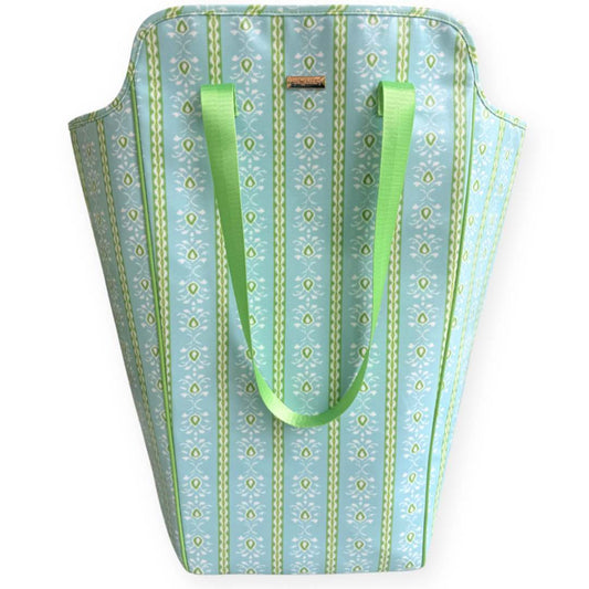 Laundry tote bag in Laura park's rosemary stripe blue pattern with durable green straps and blue, green, and white floral motifs. 