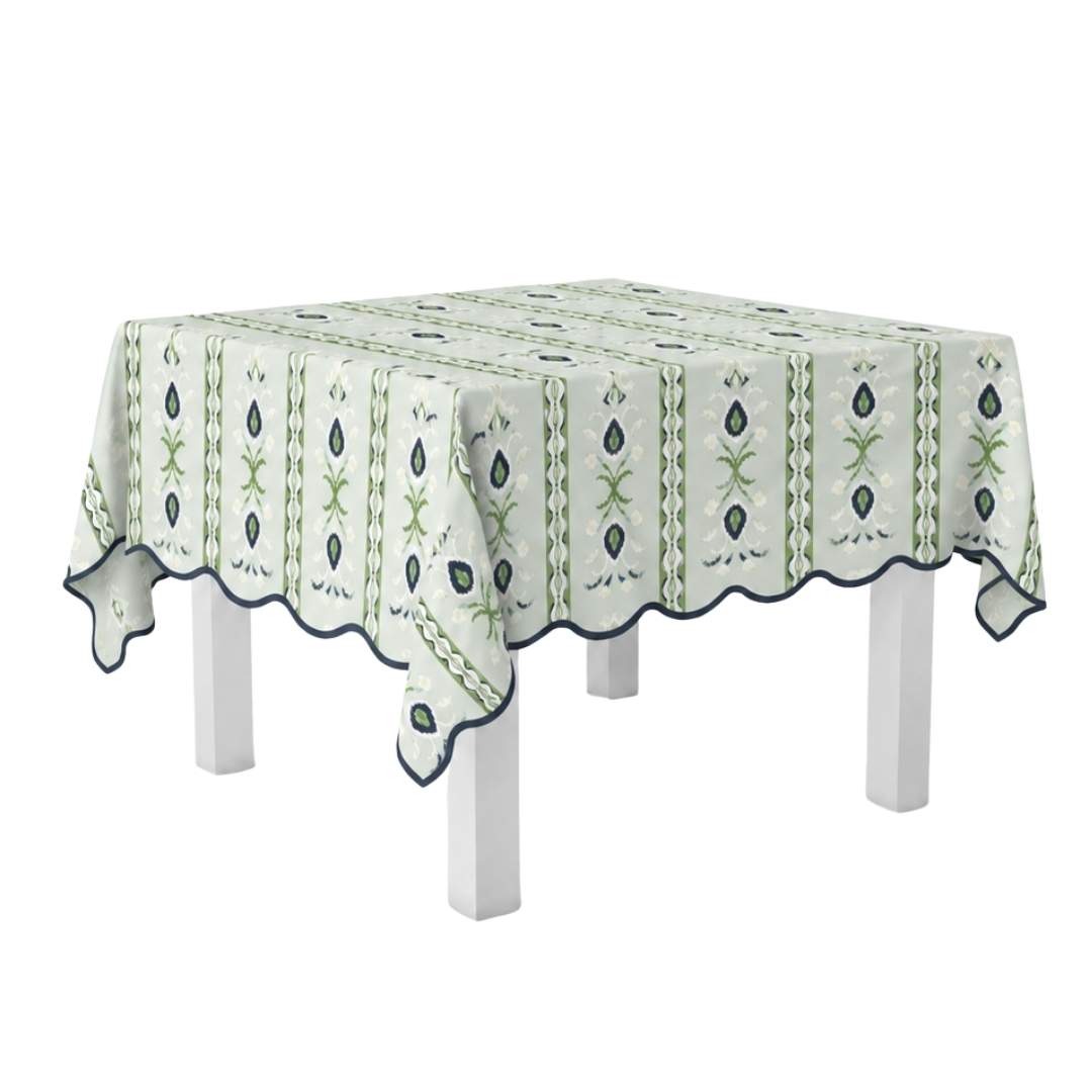 laura park rosemary stripe lagoon scalloped game table cloth for a square table with light blue, navy, and green floral accents and a navy scalloped edge. 