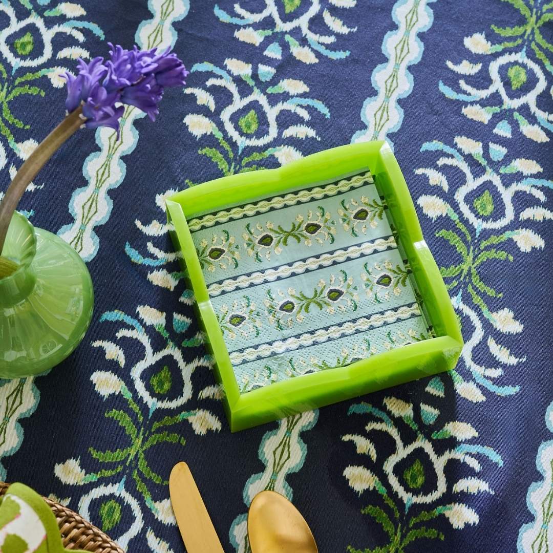 Laura park's signature indigo rosemary stripe tablecloth with blue and green pattern for hosting and entertaining as the background for this dinner table set up. 