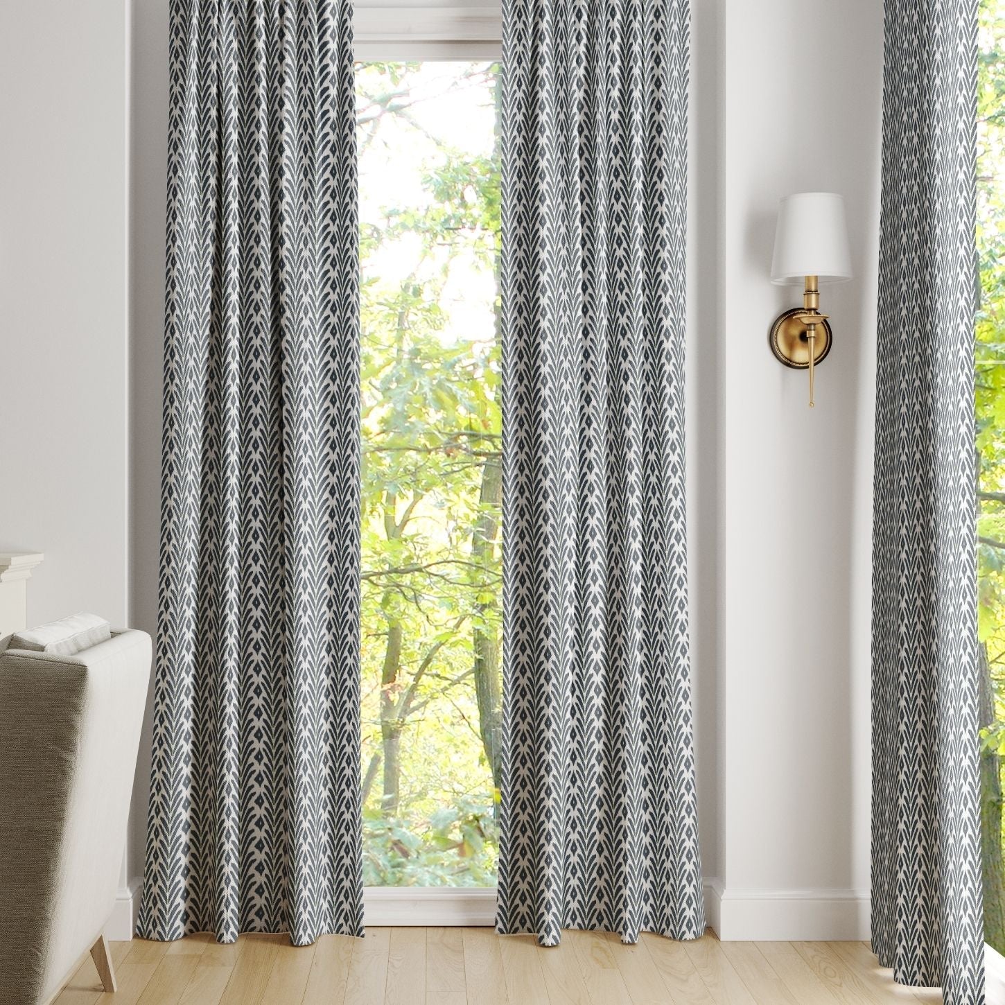 Pair of ikat inspired laura park petite frond navy rod pocket curtains on a silver curtain rod over a large arched window. 